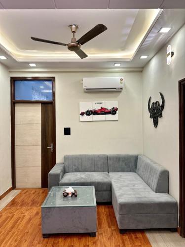 a living room with a couch and a ceiling fan at Mojo house jaipur in Jaipur