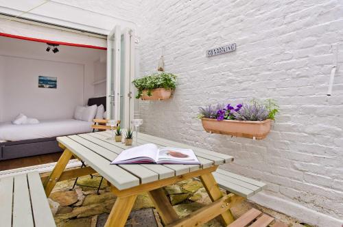 a room with a wooden table with a book on it at Charming 2-Bed Apt, Pimlico in London