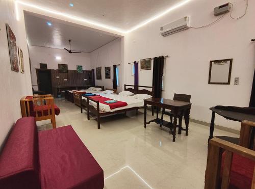 a room with beds and a table and chairs at Art Le Cafe in Auroville