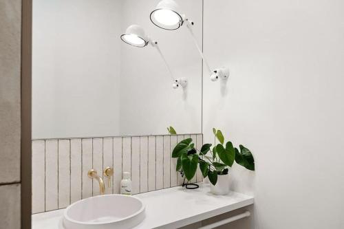 a bathroom with a white sink and a mirror at Apartment 22 - stylish retreat in central location in Fitzroy