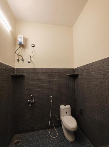 a bathroom with a white toilet in a room at Art Le Cafe in Auroville