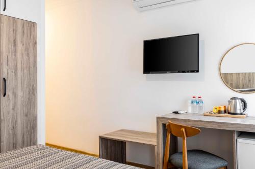 a hotel room with a desk and a tv at Costa Maya Bodrum in Bodrum City