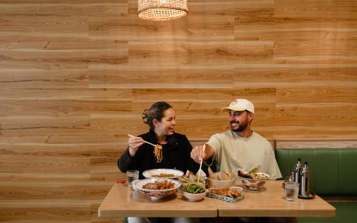 two people sitting at a table eating food at Tasman Holiday Parks - Rotorua in Rotorua