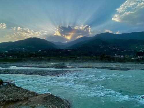 a view of a river with mountains in the background at Askari Inn Hotels in Madyan
