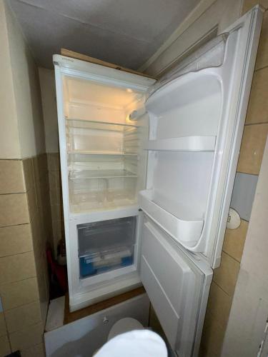 an empty refrigerator with its door open in a kitchen at Spacious Local Lounge Apartment in Kelkheim