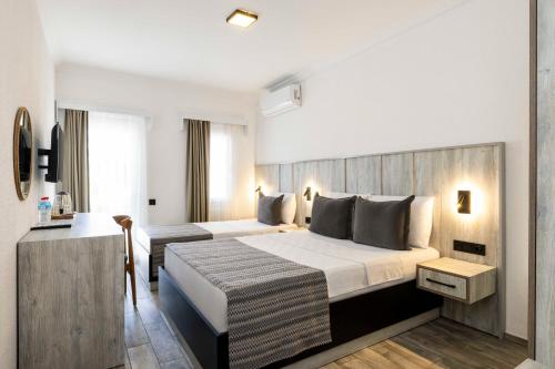 a hotel room with a bed and a desk at Costa Maya Bodrum in Bodrum City