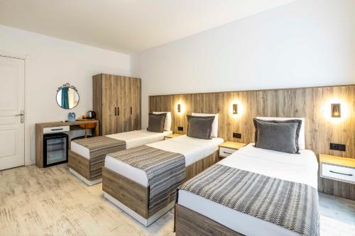 two beds in a room with wooden walls at Costa Maya Bodrum in Bodrum City