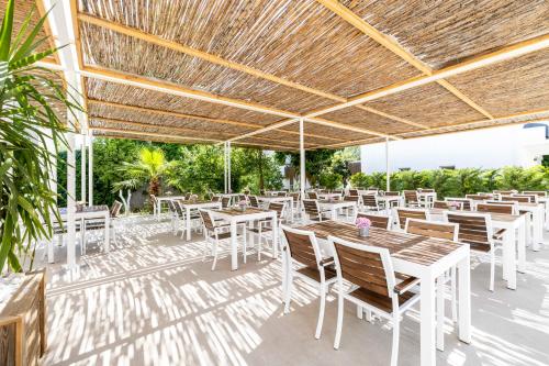 a patio with tables and chairs under a roof at Costa Maya Bodrum in Bodrum City