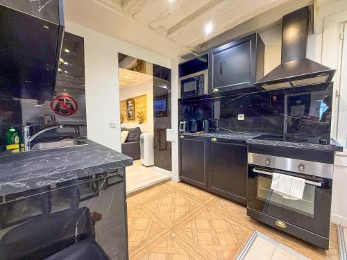 une cuisine avec un évier et une cuisinière dans l'établissement UrbanFlat 41 - Disneyland in Paris - Montorgueil, à Paris