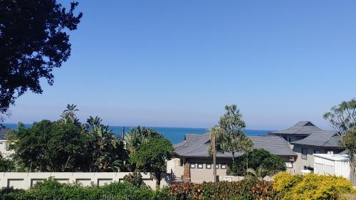 a row of houses with the ocean in the background at KERYNMERE, Zinkwazi Beach in Zinkwazi Beach