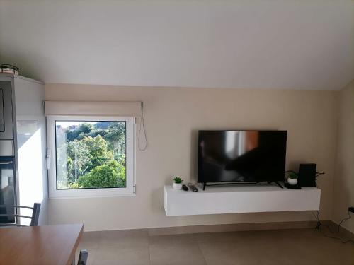 a living room with a flat screen tv on a wall at House Vila Santa Ana in Santana