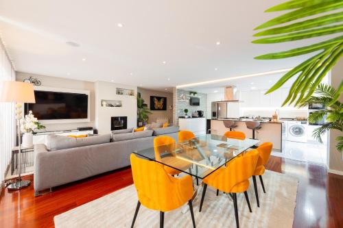 a living room with a glass table and yellow chairs at appartement tout confort dans résidence privée in Apúlia