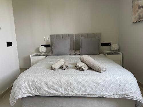 a white bed with two towels and pillows on it at Panoramic Montain in Cabrils