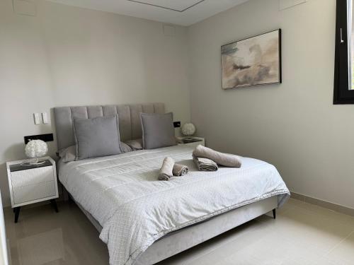 a white bedroom with a large bed with towels on it at Panoramic Montain in Cabrils