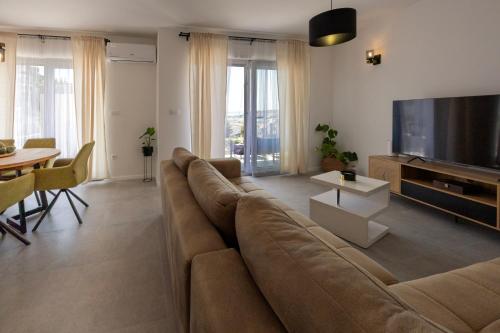a living room with a large couch and a television at NU Sea View in Podstrana