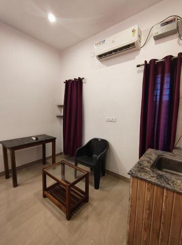 a room with a sink and a table and a chair at Art Le Cafe in Auroville