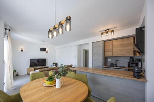 a kitchen and living room with a wooden table at NU Sea View in Podstrana
