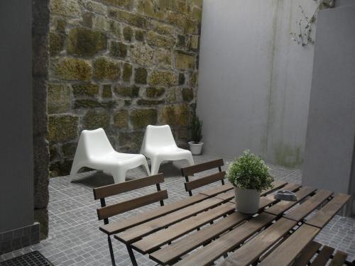 2 chaises blanches, un banc en bois et une table dans l'établissement Your Place Porto II, à Porto