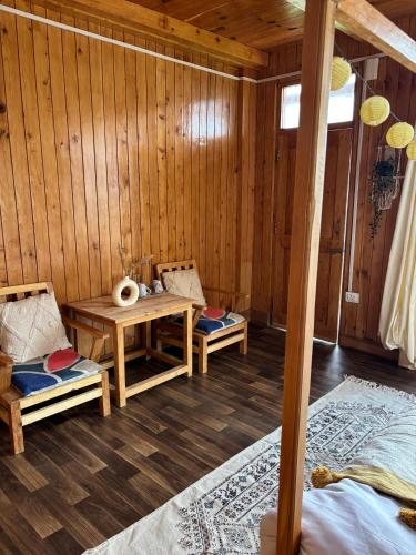 a room with two chairs and a table in a cabin at Baserah Stay & Cafe in Mandi