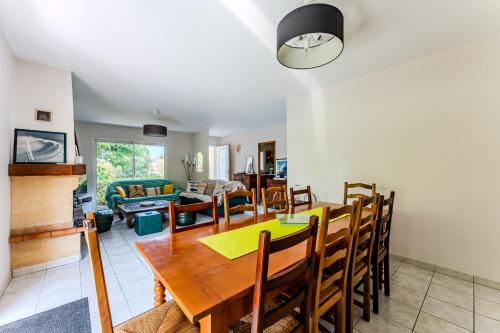 a dining room and living room with a table and chairs at Villa Les Tamaris 8 Personnes in La Teste-de-Buch