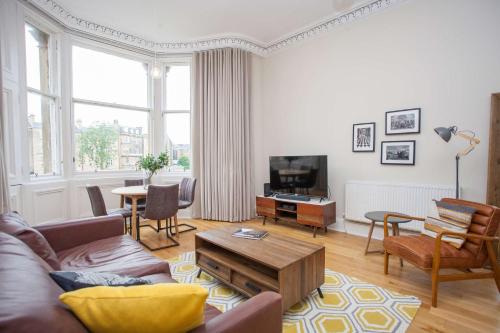a living room with a couch and a table at Spacious Period Property in Glasgow in Glasgow