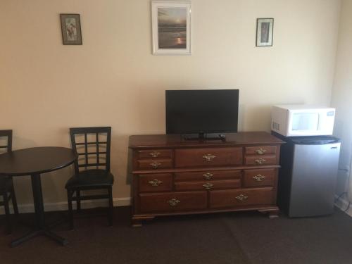 a room with a dresser with a television and a microwave at Misquamicut Beach Front Inn in Misquamicut