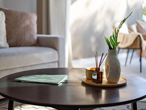 a coffee table in a living room with a vase at Sanders Breeze Limassol in Limassol