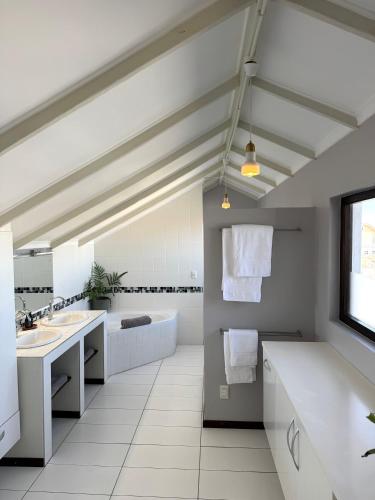 a white bathroom with two sinks and a tub at Salty Villa in Swakopmund