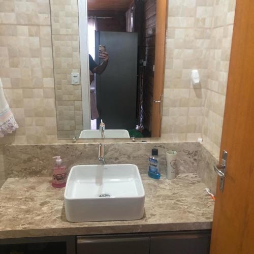 a person taking a picture of a bathroom sink at Cabana Invernador II in Urubici