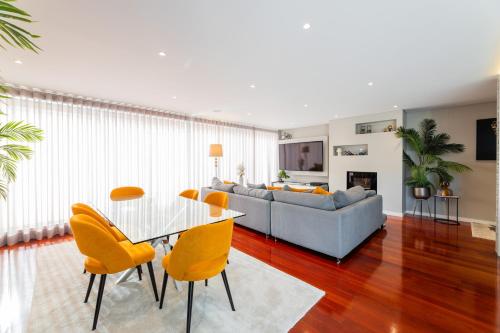 a living room with a couch and a table and chairs at appartement tout confort dans résidence privée in Apúlia