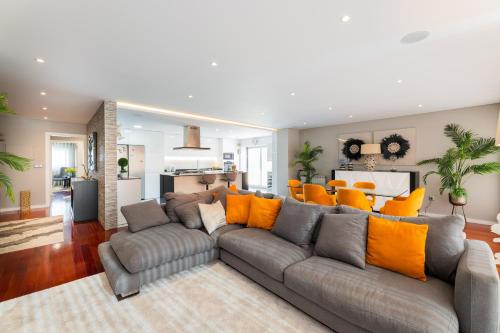 a living room with a gray couch and orange pillows at appartement tout confort dans résidence privée in Apúlia