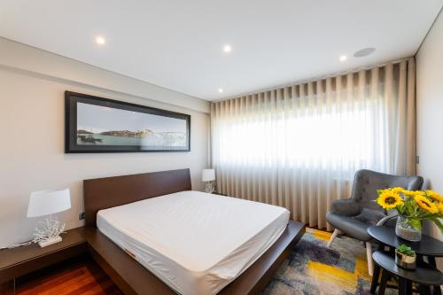 アプーリアにあるappartement tout confort dans résidence privéeのベッドと椅子と窓のある寝室