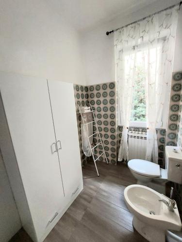 a bathroom with a toilet and a sink and a window at La Brezza di lago in Baveno