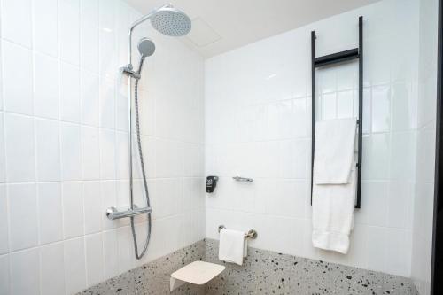 a white bathroom with a shower and a toilet at Ibis Styles Dakar in Dakar