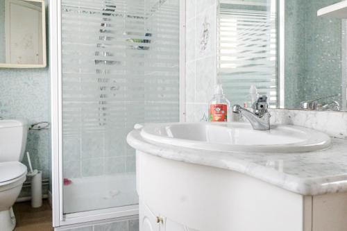 Un baño blanco con lavabo y ducha. en Appartement charmant hyper centre, en Les Sables-dʼOlonne
