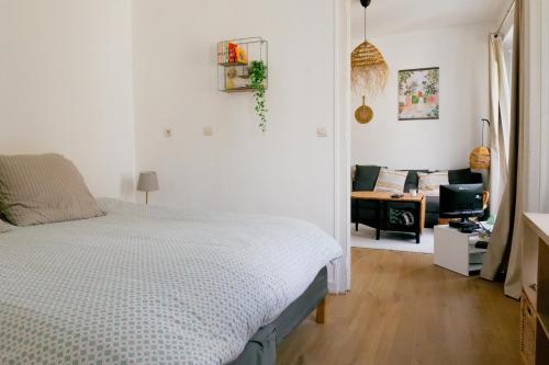 Un dormitorio blanco con una cama y un sofá. en Appartement charmant hyper centre, en Les Sables-dʼOlonne