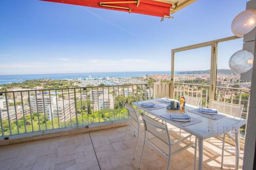 une salle à manger avec une table et des chaises sur un balcon dans l'établissement Smart flat in Antibes sea view AC parking and pool, à Antibes