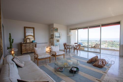 un salon avec un canapé et une table en verre dans l'établissement Smart flat in Antibes sea view AC parking and pool, à Antibes