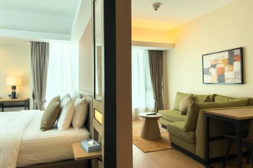 a hotel room with a bed and a couch at The Everly Putrajaya in Putrajaya