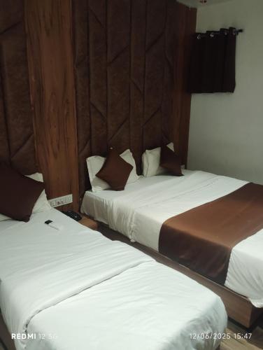 two beds sitting next to each other in a room at Hotel Pera Villa in Gandhinagar