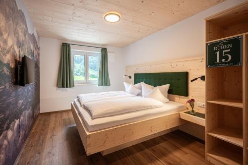 a bedroom with a bed and a sign on the wall at RUBEN 15 Ferienwohnungen in Oberstdorf