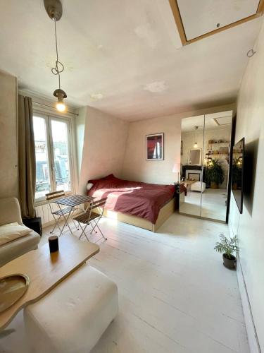 une chambre avec un lit, une table et des chaises dans l'établissement Cocon lumineux sous les toits de Paris, à Paris