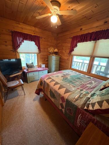 a bedroom with a bed in a log cabin at Camp Quityerbellyachin in Greenville