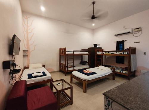 a living room with two bunk beds and a couch at Art Le Cafe in Auroville