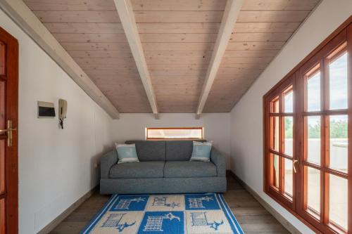 a living room with a couch and a window at Beachfront villa with direct access -Private pool & Zen Area in Quartu SantʼElena