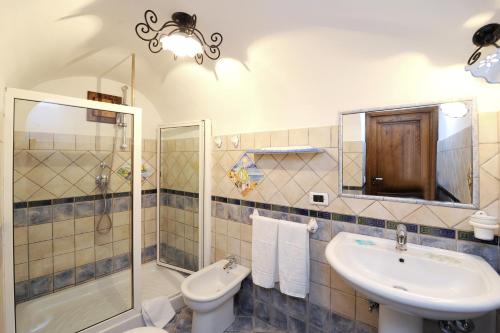 łazienka z umywalką, toaletą i prysznicem w obiekcie La Casa Del Melograno w mieście Furore