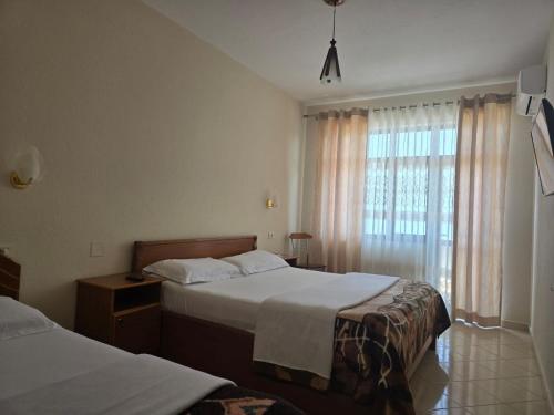 a hotel room with two beds and a window at Hotel Belvedere in Pogradec