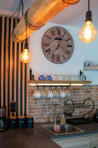 a clock on the wall above a kitchen sink at Family HOUSE in Witów
