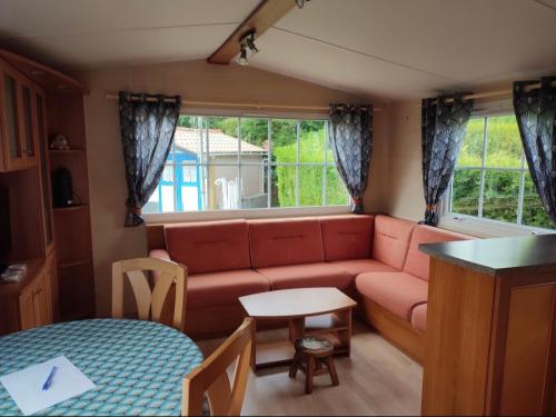 una sala de estar con un sofá y una mesa en Camping de la Pierre d Orge, en Villers-sur-Authie