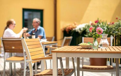 Un hombre y una mujer sentados en una mesa en un restaurante. en Augarten Apartments, en Viena